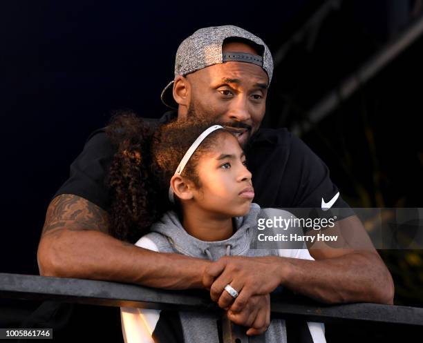 Kobe Bryant and daughter Gianna Bryant watch during day 2 of the Phillips 66 National Swimming Championships at the Woollett Aquatics Center on July...