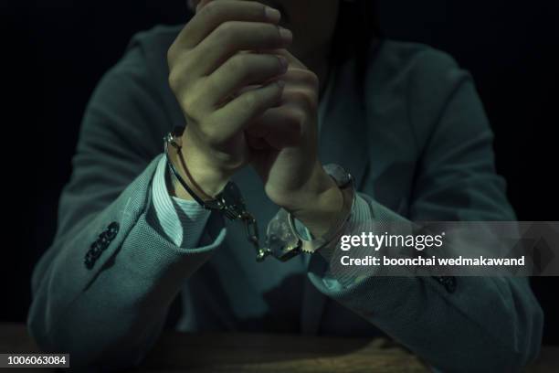 upset handcuffed man imprisoned for financial crime, punished for serious fraud - criminal fotografías e imágenes de stock