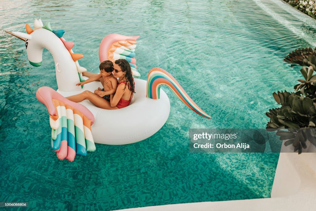 Mother with son on inflatable unicorn