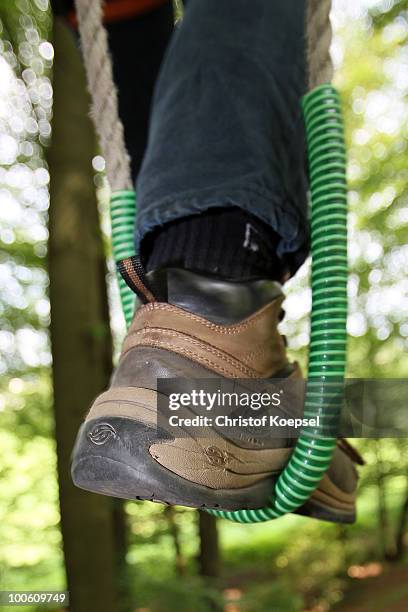 Climber hangs with his shoe in a rope during a climbing session at the GHW tightrobe climbing garden on May 25, 2010 in Hueckeswagen, Germany.