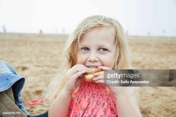 child eating a picnic at the beach - toddler eating sandwich stock-fotos und bilder