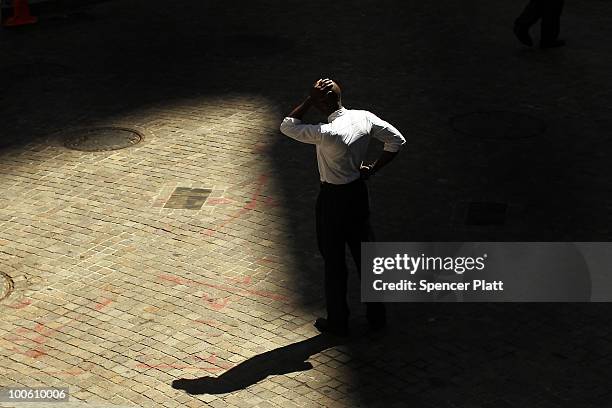 Businessman pauses along Wall Street in front of the New York Stock Exchange on May 25, 2010 in New York City. After significant morning losses, the...