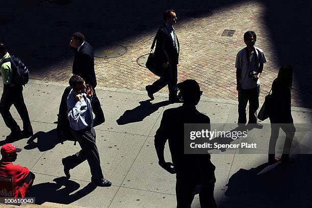 People walk along Wall Street in front of the New York Stock Exchange on May 25, 2010 in New York City. After significant morning losses, the Dow...