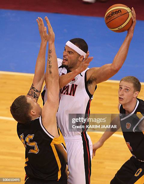 Vsevolod Fadeikin of Kazakhstan's Astana Tigers tries to block Michael D'Andre Fey of Qatar's Al-Rayyan during their 21st FIBA Asia Champions Cup...