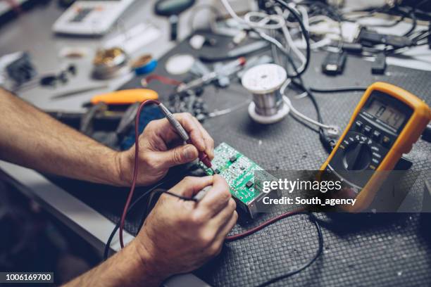 reparatör kontroll av spänning med digital multimeter - elektronikindustri bildbanksfoton och bilder