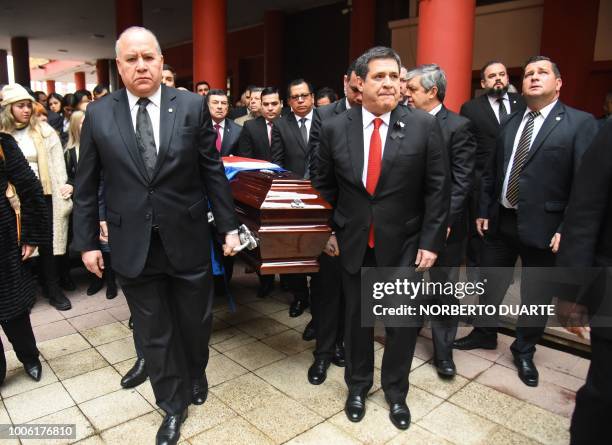 Paraguayan President Horacio Cartes and his political advisor Dario Filartiga help carry the coffin of late Agriculture Minister Luis Gneiting, who...