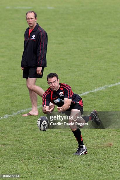 Neil de Kock passes the ball watched by coach Brendan Venter during the Saracens training session on May 25, 2010 in St Albans, England.