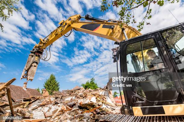 bauarbeiter einen bagger bei einem abriss-baustelle in betrieb - heavy demolition stock-fotos und bilder
