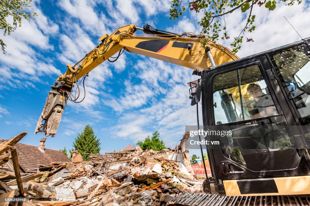 Construction worker operating an excavator at a demolition site