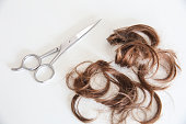 haircut scissor and locks of hair in a white background