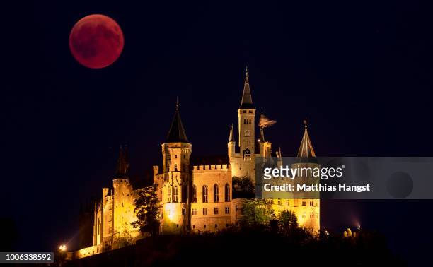 Blood Moon rises behind The Hohenzollern Castle, the ancestral seat of the Prussian Royal House and of the Hohenzollern Princes, situated at the...