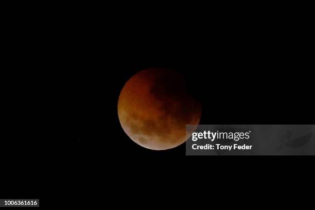 The Lunar eclipse is seen over Tuggerah Lake on the Central Coast of NSW on July 28, 2018 in Sydney, Australia. During this eclipse, when Earth's...