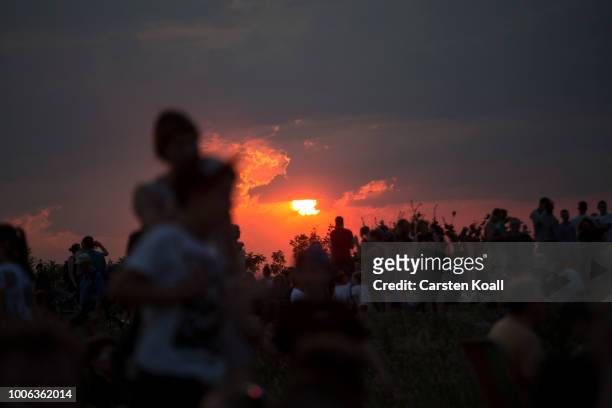 People gather in the sunset to await the rising of the blood Moon in on July 27, 2018 in Berlin, Germany. The period of totality during this eclipse,...