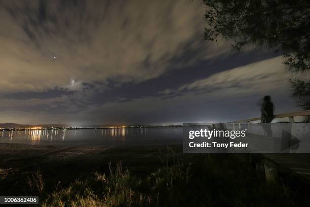 People watch the Lunar eclipse over Tuggerah Lake on the Central Coast of NSW on July 28, 2018 in Sydney, Australia. During this eclipse, when...