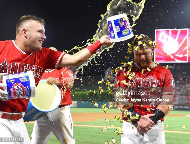 Kole Calhoun gets a bubble gum and sports drink shower from Mike Trout and Jose Briceno of the Los Angeles Angels of Anaheim after hitting a walk off...