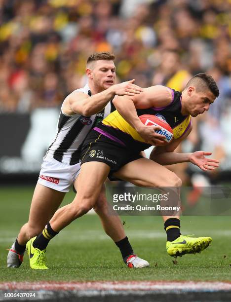 Dion Prestia of the Tigers is tackled by Taylor Adams of the Magpies during the round 19 AFL match between the Richmond Tigers and the Collingwood...