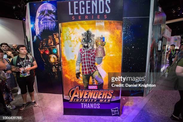 Fan dressed in a homemade animal costume poses inside a life-size Avengers action figure box at the Hasbro Toy booth at Comic-Con International on...