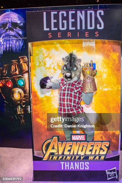 Fan dressed in a homemade animal costume poses inside a life-size Avengers action figure box at the Hasbro Toy booth at Comic-Con International on...