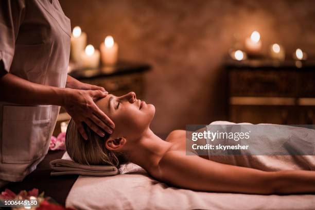joven mujer teniendo masaje facial en el spa de salud. - masaje facial fotografías e imágenes de stock