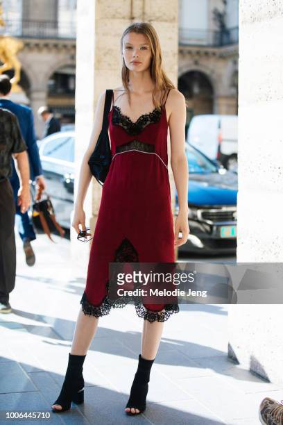 Kris Grikaite exits the Valentino show in a red slip dress with black fringe and open-toe black booties during Paris Fashion Week Mens Spring/Summer...