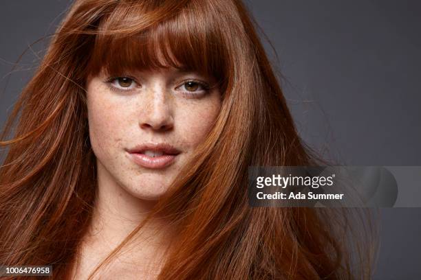 smiling woman with windblown red long hair - beautiful redhead photos et images de collection