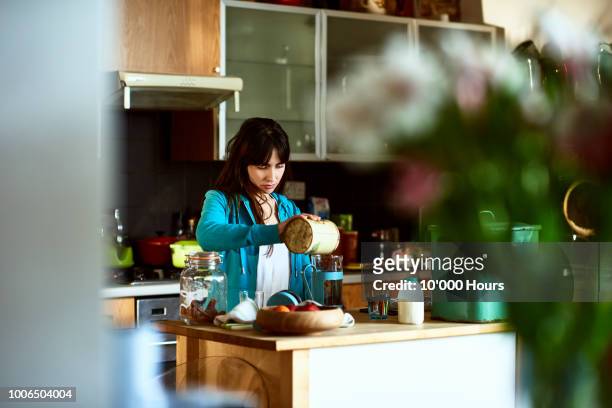 young woman making fresh coffee in cafetiere in kitchen - making stock-fotos und bilder