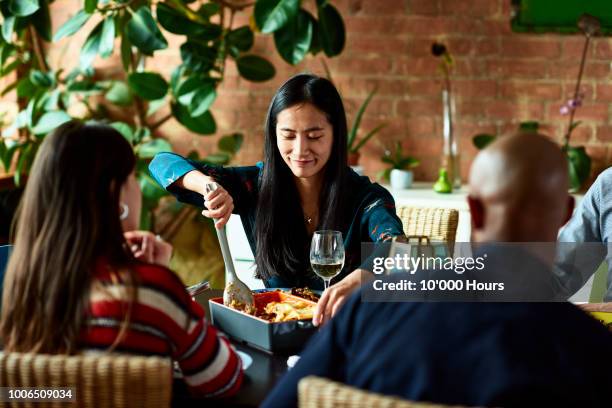 mid adult chinese woman serving home made dish at meal time - serving lasagna stock pictures, royalty-free photos & images