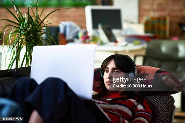 attractive young hispanic woman watching movie on laptop - downloading stock pictures, royalty-free photos & images