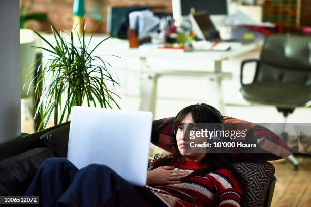 emotional young woman using laptop and looking upset - watch stock pictures, royalty-free photos & images