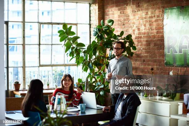 creative professionals in studio having meeting and smiling - hipster office stock pictures, royalty-free photos & images