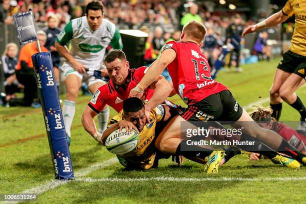 Julian Savea of the Hurricanes breaks through the tackle of Ryan Crotty and Jack Goodhue of the Crusaders to score a try during the Super Rugby Semi...