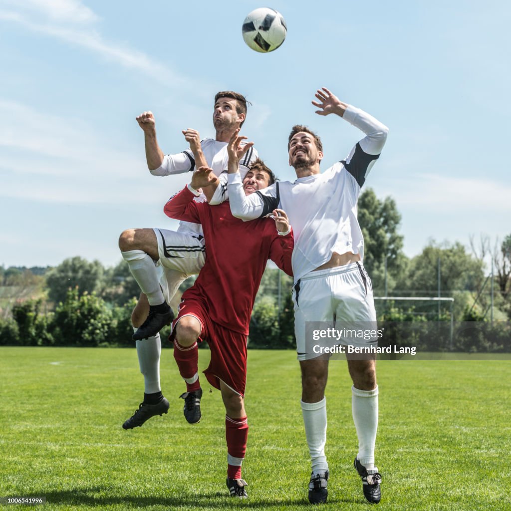 Three Soccer Players jumping for ball