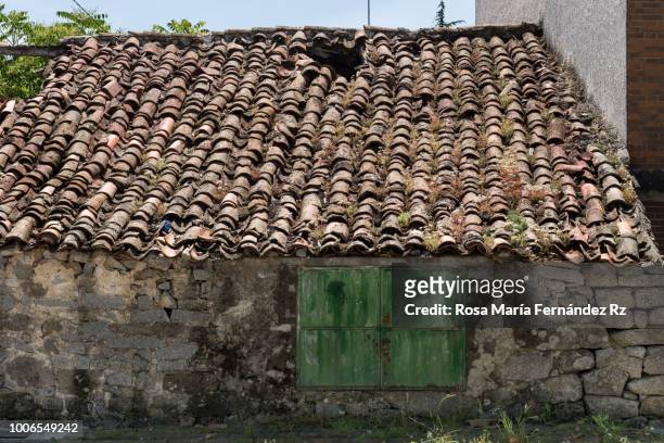 facade and roof of an ancient and abandoned house with a door of wood in small village near to madrid, spain. - abandoned crack house stock pictures, royalty-free photos & images
