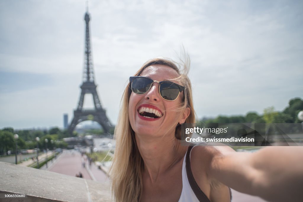 Young woman taking selfie in Paris city using mobile phone