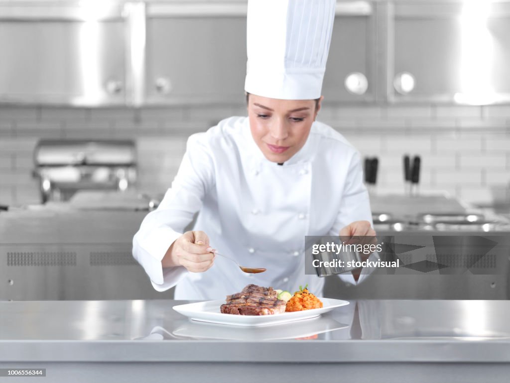 Feminino chef preparando o prato de bife