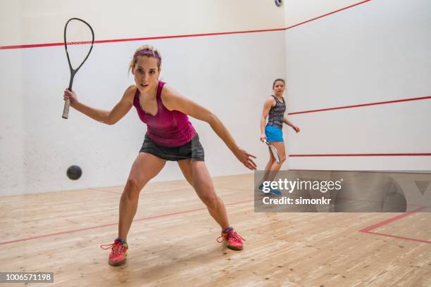 two young women playing squash game - woman playing squash stock pictures, royalty-free photos & images