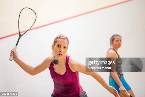 zwei junge frauen spielen squash-spiel - squash racquet stock-fotos und bilder