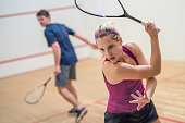 Young man and woman playing squash game