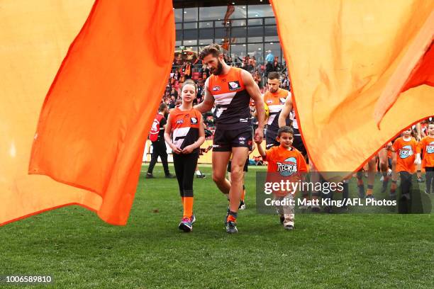 Callan Ward of the Giants leads the Giants through the banner during the round 19 AFL match between the Greater Western Sydney Giants and the St...