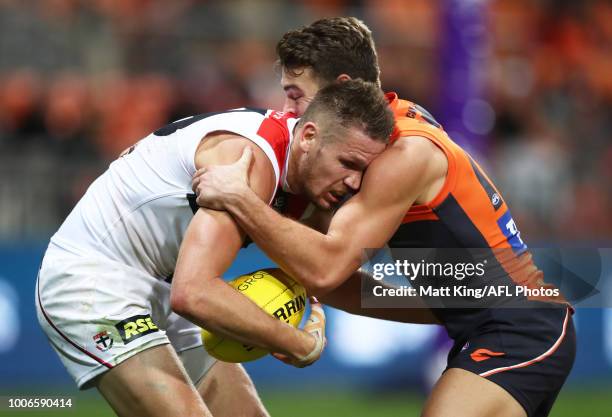 Sam Gilbert of the Saints is tackled by Zac Langdon of the Giants during the round 19 AFL match between the Greater Western Sydney Giants and the St...