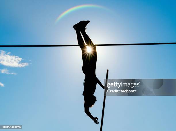 pole vault action, male athlete, against the sun - pole vault stock pictures, royalty-free photos & images