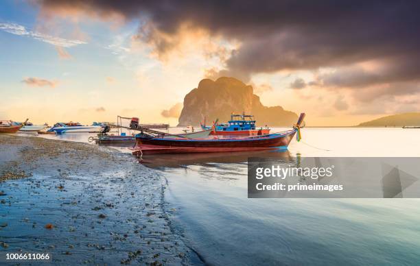 美麗的日落在熱帶海與長的尾巴小船董裡省在泰國南部 - phuket province 個照片及圖片檔