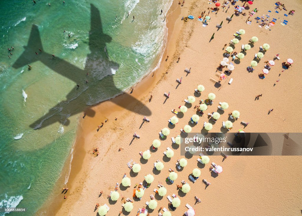 Vista aérea avión sombra y playa con sombrillas