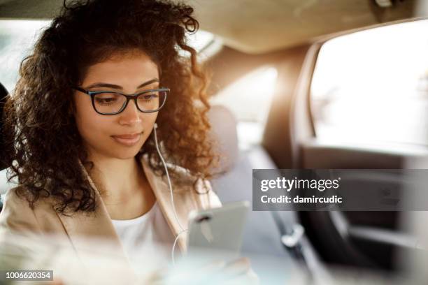 businesswoman using smart phone in a car - music from the motor city stock pictures, royalty-free photos & images