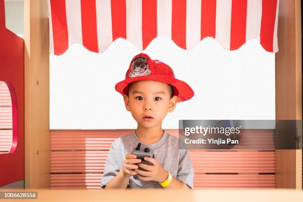 portrait of a baby boy wearing a fire helmet - firefighter's helmet stock pictures, royalty-free photos & images