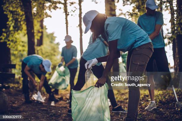 freiwillige mit müllsäcke - umweltschutz reinigungsaktion stock-fotos und bilder