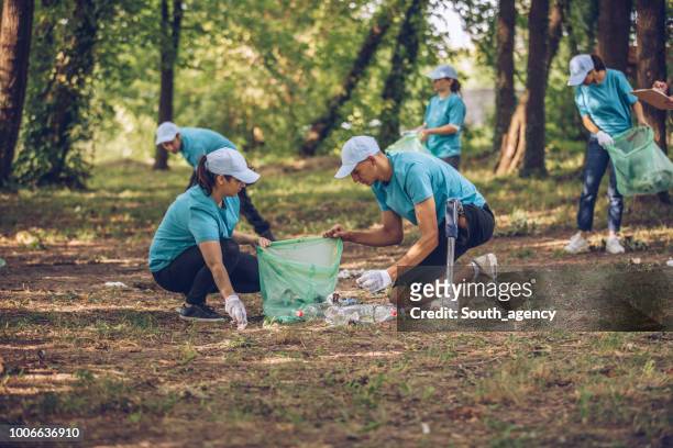 volunteers collecting garbage in nature - disability collection stock pictures, royalty-free photos & images