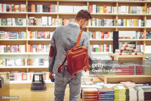 若い男ショッピング書籍 - bookstore ストックフォトと画像