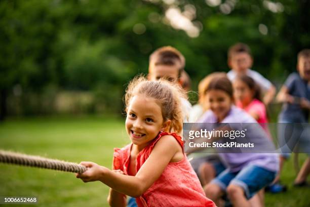 group of kids pulling a rope - strength stock pictures, royalty-free photos & images