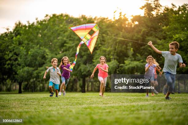 niños felices para un vuelo del dragón - cometa fotografías e imágenes de stock